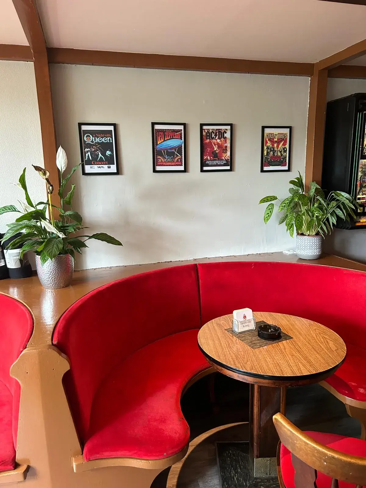 Die rote Rundbank mit Konzertplakaten an der Wand